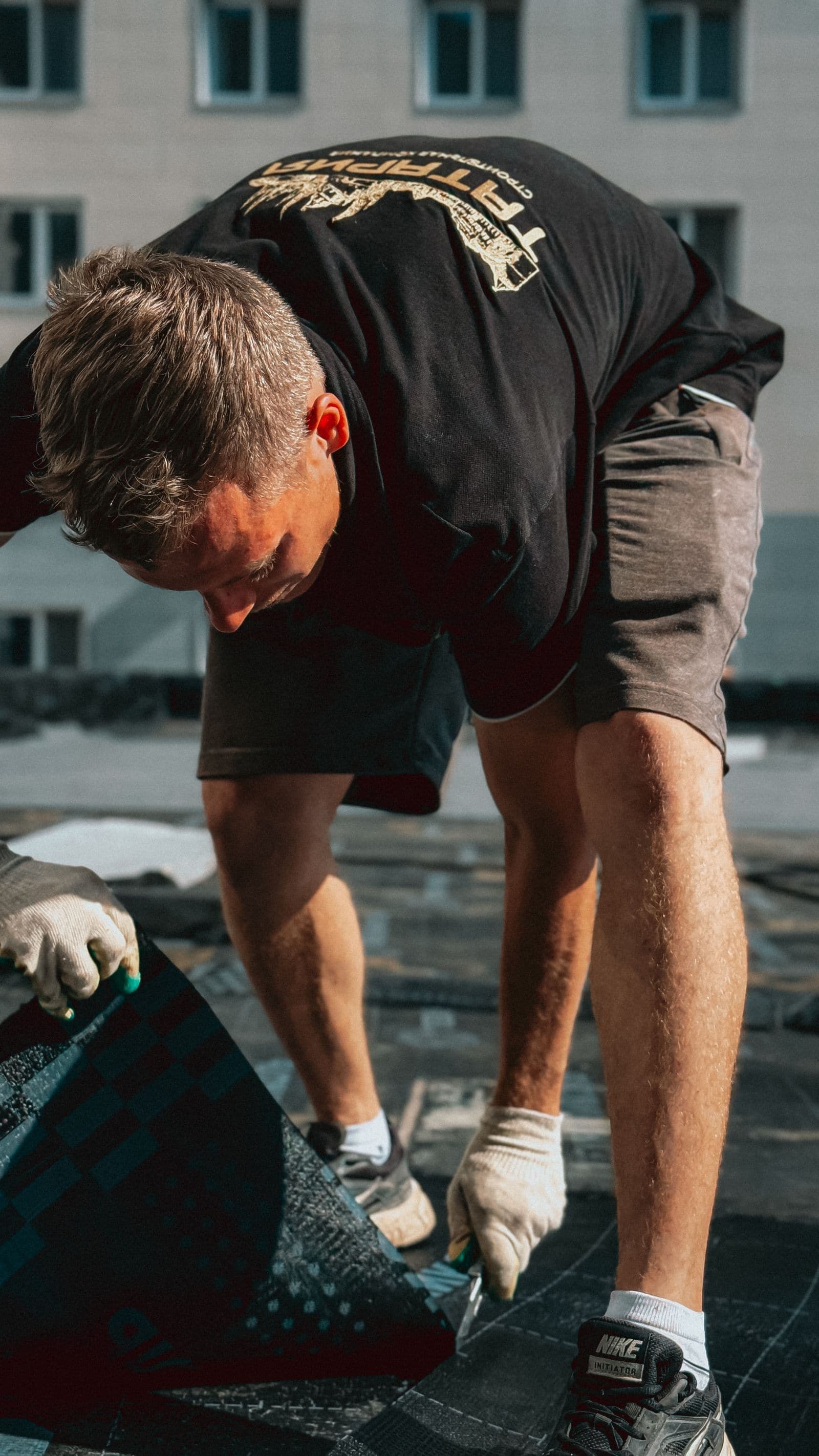 Roofer laying replacement asphalt shingles