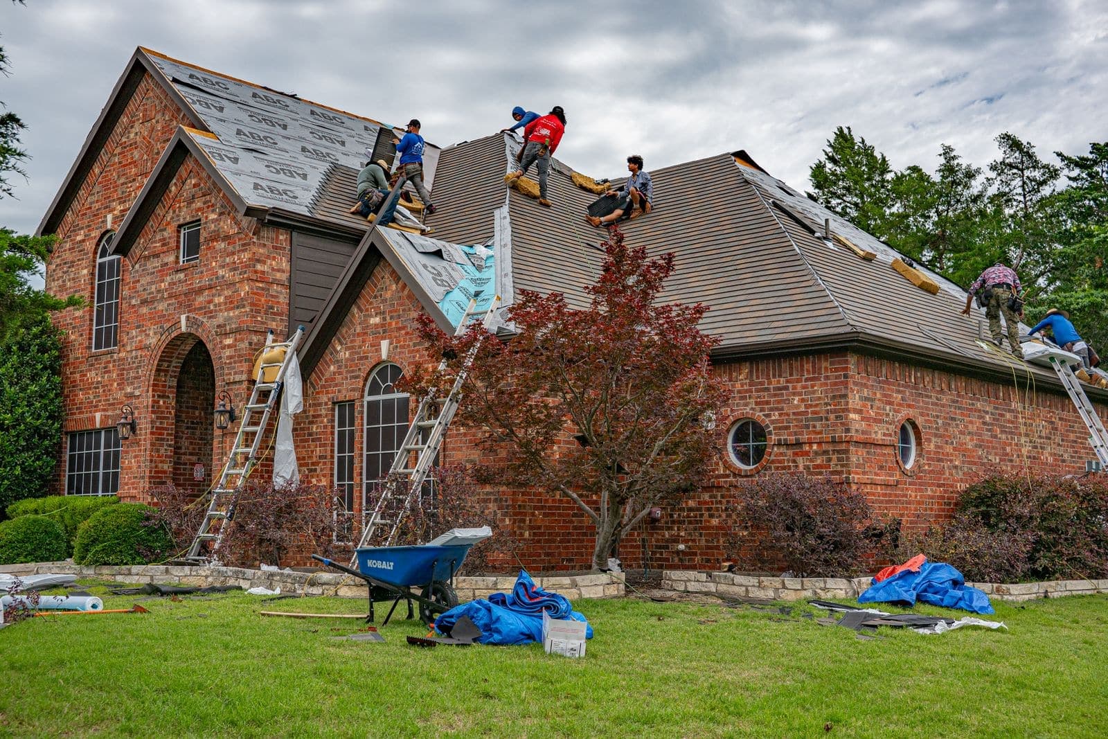 Roofing crew replacing the roof on a brick home in Texas
