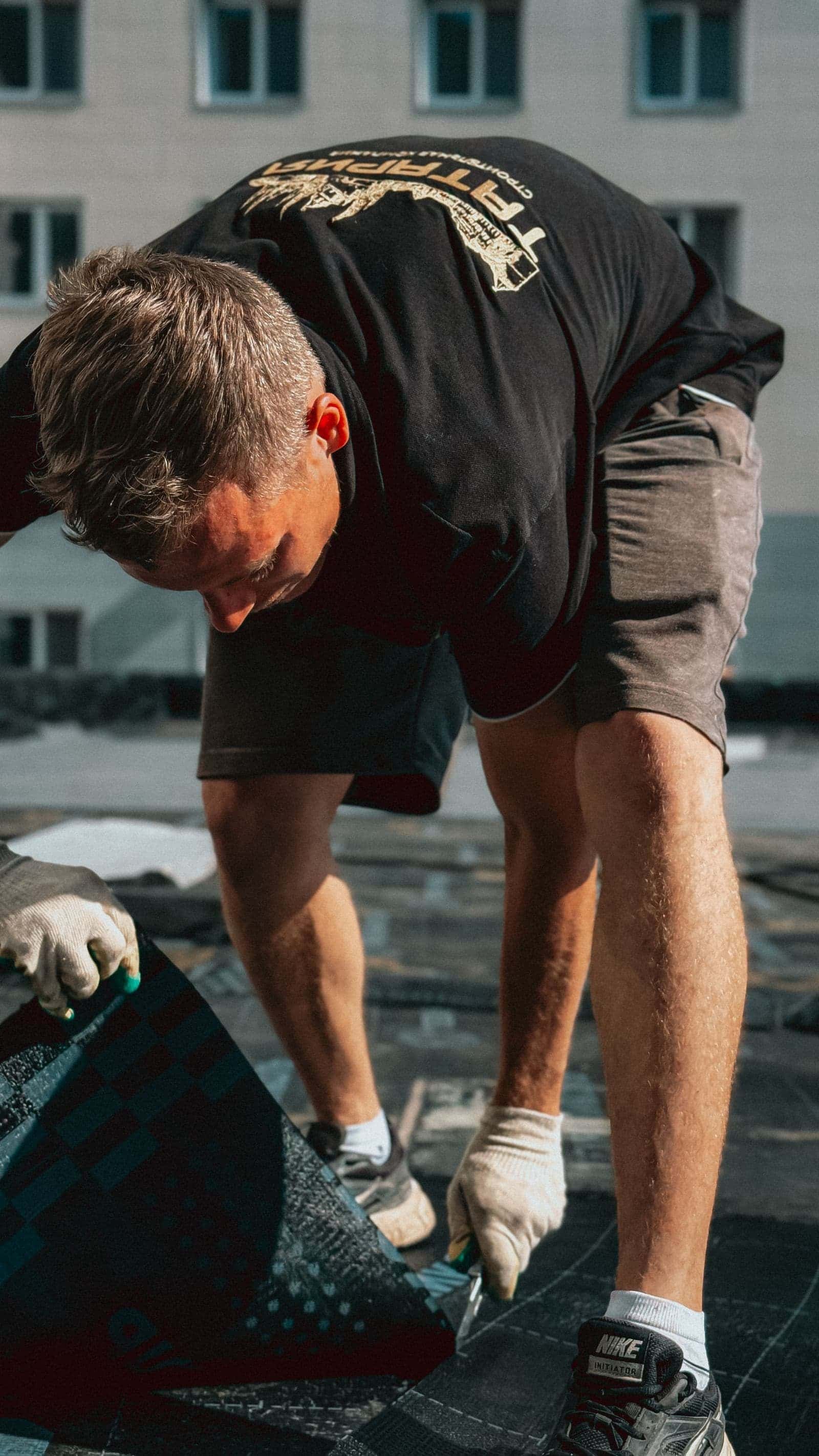 Roofer laying replacement asphalt shingles