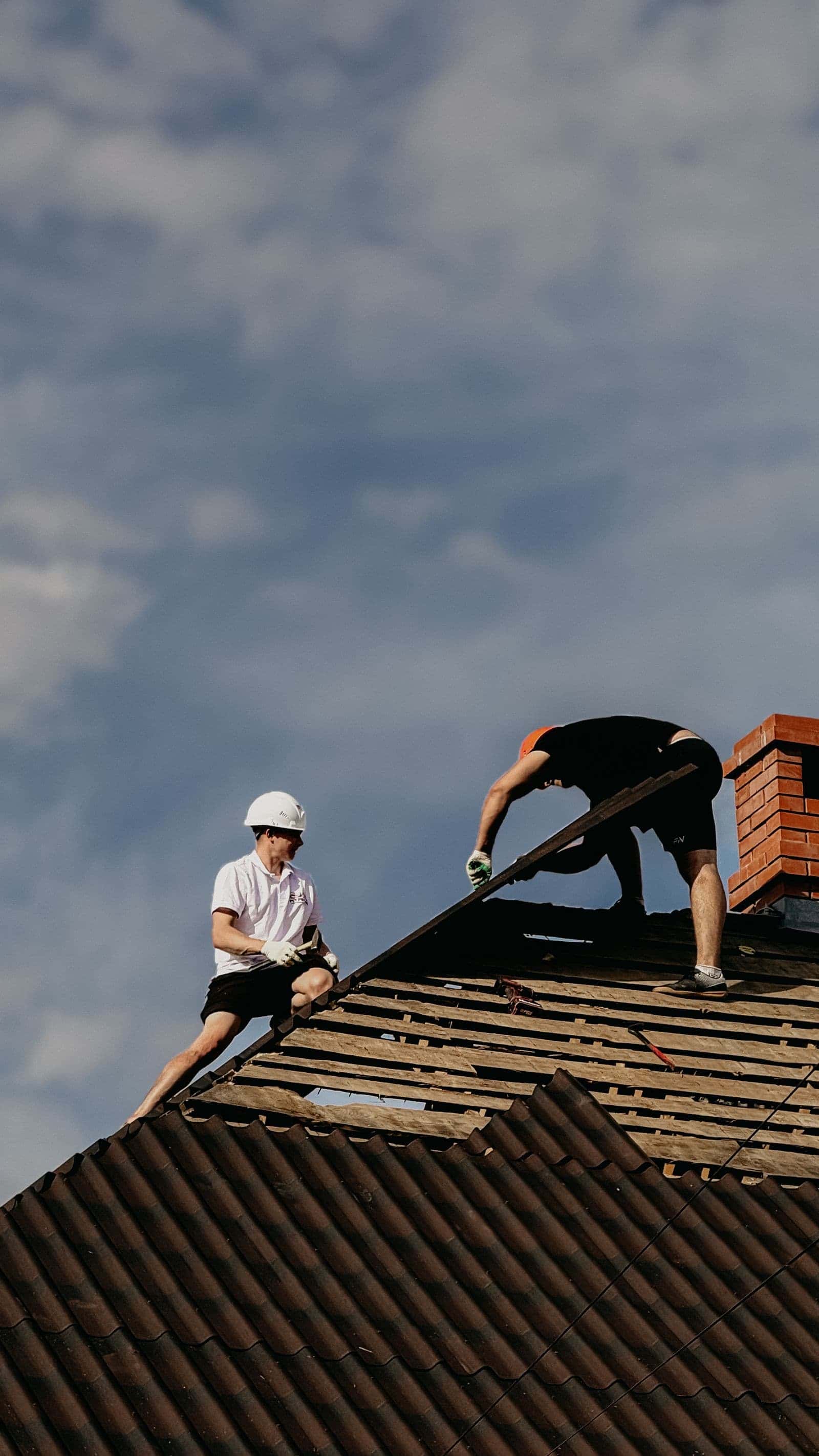 Roofers repairing a storm-damaged roof